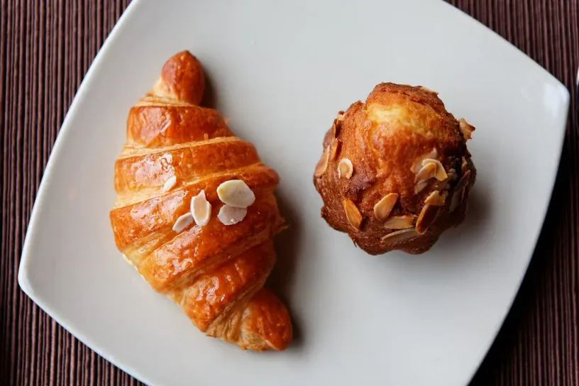 The original photo: a croissant and an almond muffin on a white plate, from above